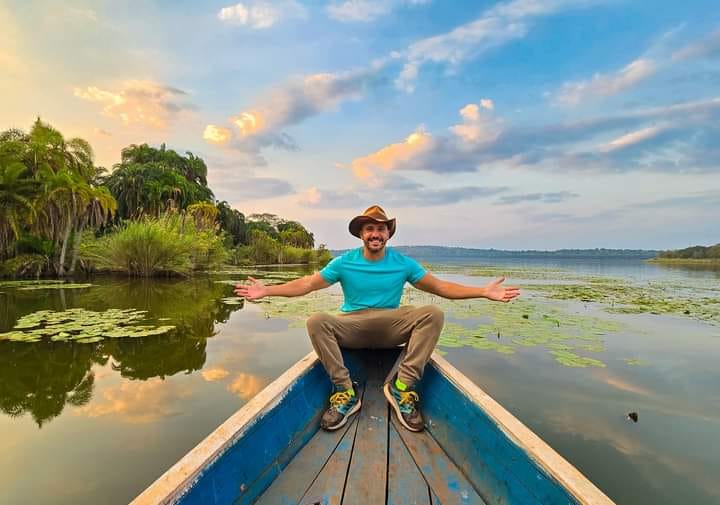 Guest on a wooden boat gliding through water lilies