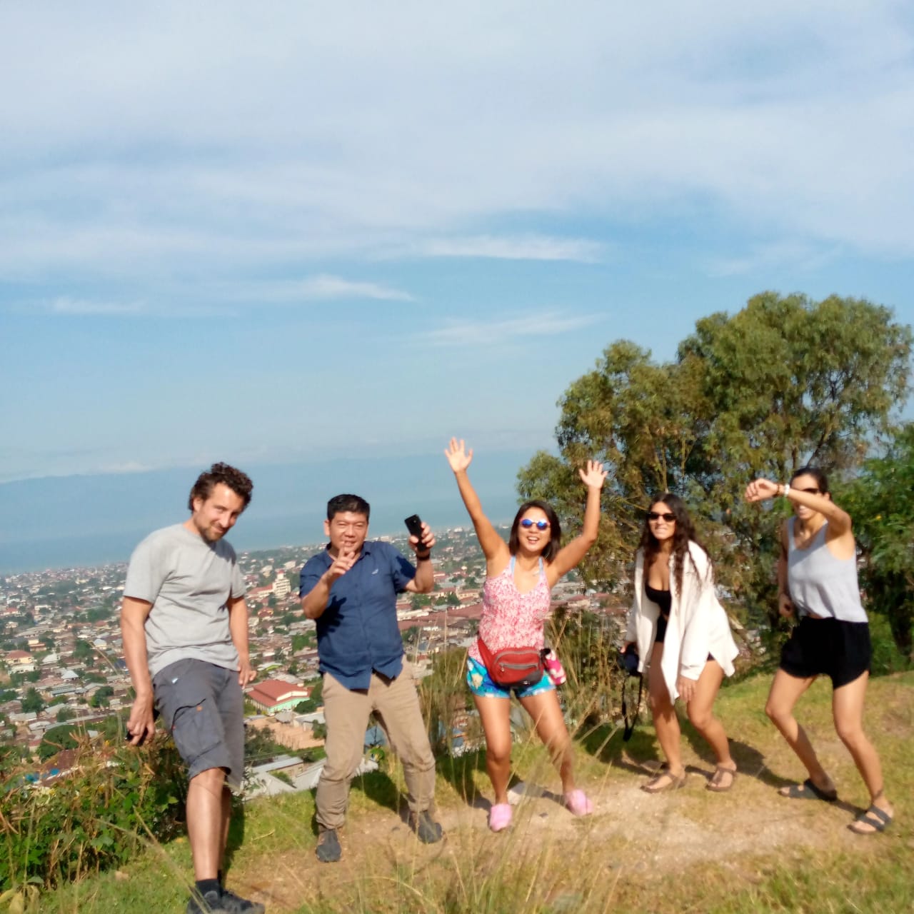 Travellers jumping for a photo on a hilltop above Bujumbura